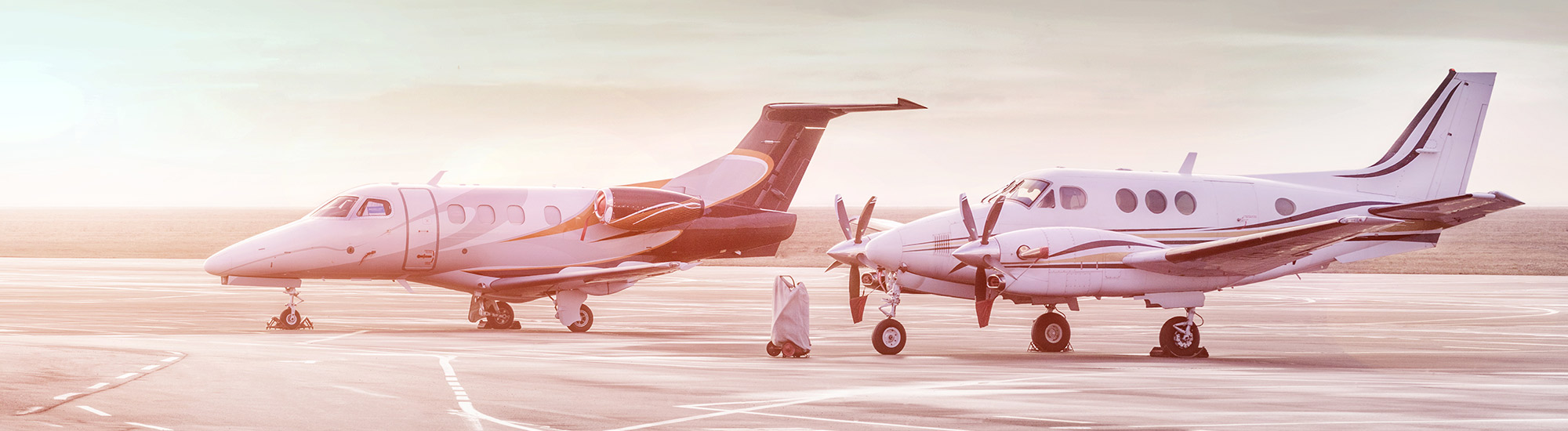 two airplanes on runway at sunrise