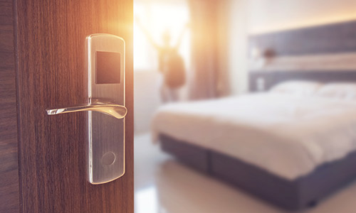 hotel room door knob with open door and blurry room